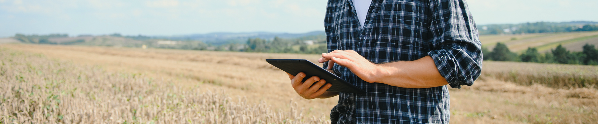 Estudante caminhando pelo campus segurando alças da mochila com suas mãos. 