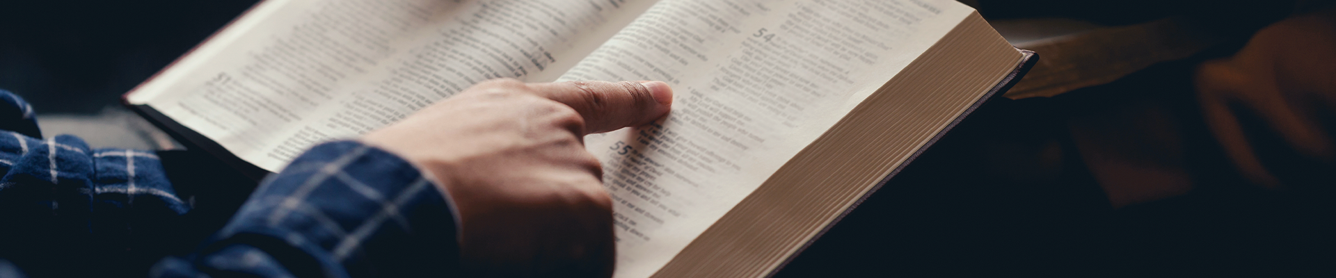 Estudante caminhando pelo campus segurando alças da mochila com suas mãos. 