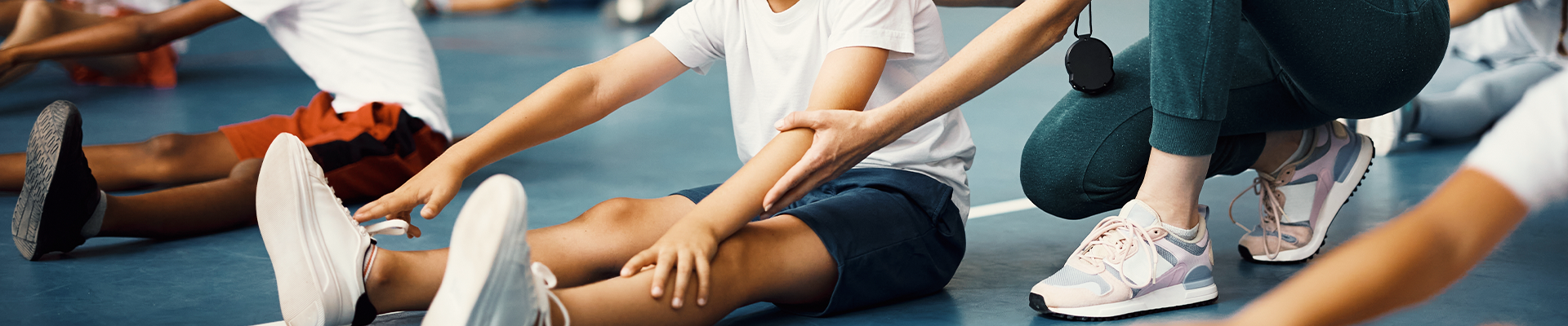 Estudante caminhando pelo campus segurando alças da mochila com suas mãos. 